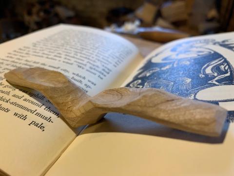 a wooden page holder holds open a book