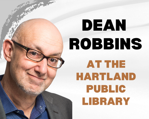 a man with glasses smiles at the camera