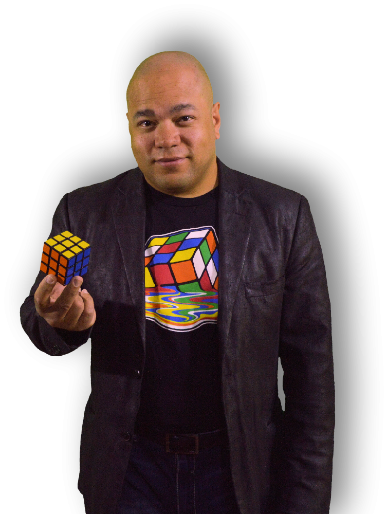 A man in a leather jacket holds up a Rubik's cube.